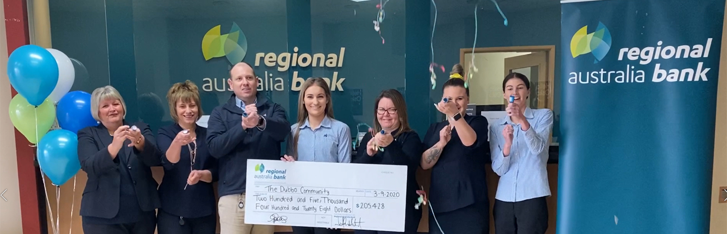Staff from Dubbo Branch celebrating with poppers and a large cheque displaying over $200k donated back to Dubbo community