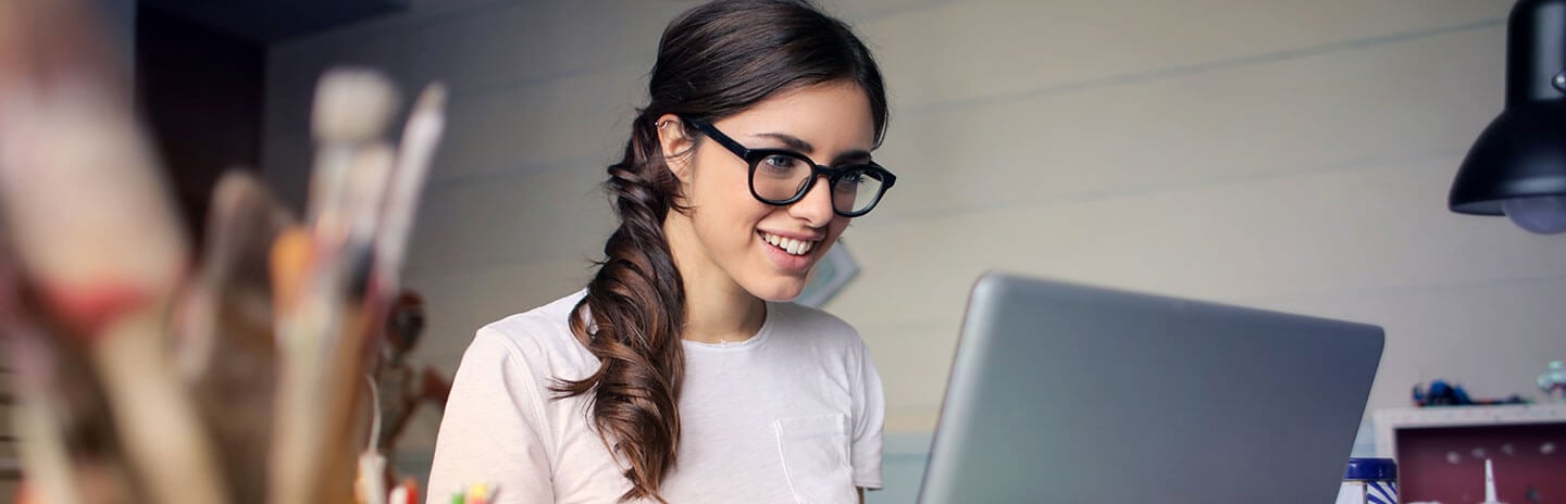 Women with glasses works at laptop